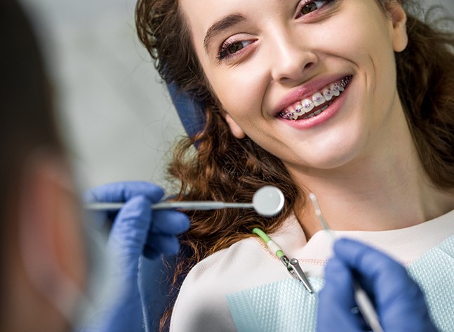 A cheerful woman with braces seeing her dentist for a checkup