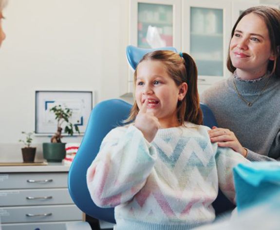 Young dental patient pointing at her teeth