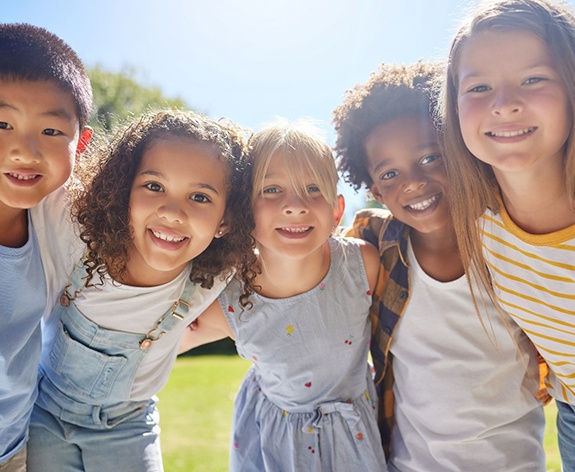 Group of childhood friends embracing outdoors
