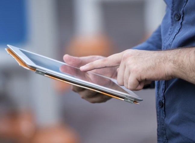 Person typing on tablet screen