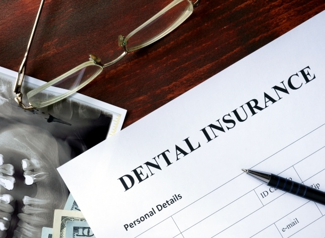 Dental insurance form on dark wood table