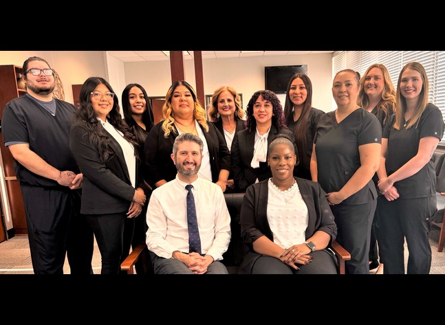 Oklahoma City orthodontist and team smiling in reception area of Casady Square Orthodontics