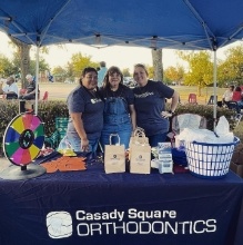 Orthodontic team members at Casady Square Orthodontics table at community event