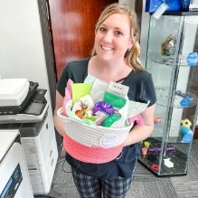 Young woman holding gift basket in orthodontic office