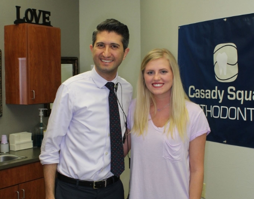 Doctor Ishani posing with young blonde woman in orthodontic office