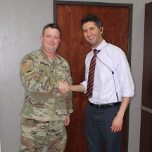 Doctor Ishani shaking hands with a man in camo military uniform