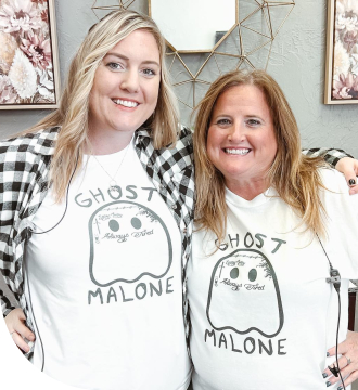 Two smiling orthodontic team members wearing matching T shirts with tattooed ghosts saying Ghost Malone