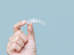 Closeup of patient holding Invisalign aligner