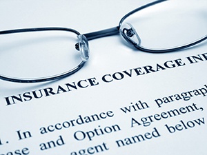 Glasses lying on dental insurance paperwork