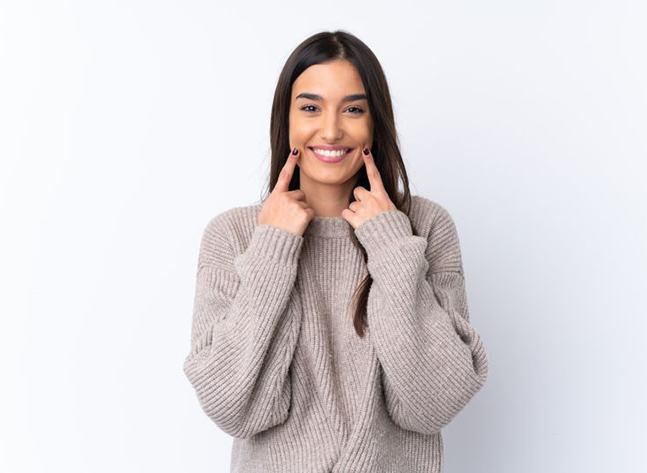 Happy woman pointing at her smile