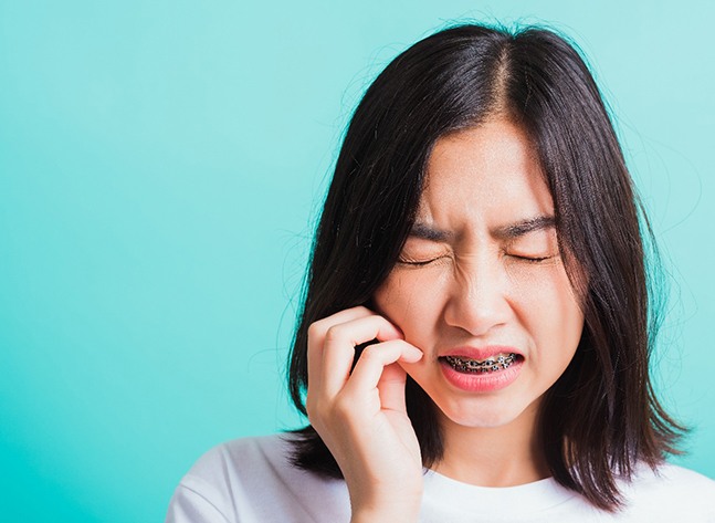 A teen with braces facing a severe toothache