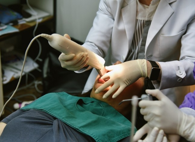 Orthodontist taking digital dental impressions of a patient