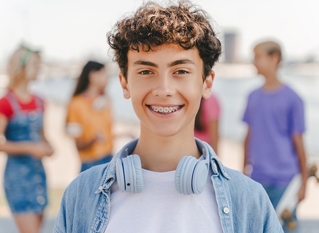 a teenager with headphones around his neck