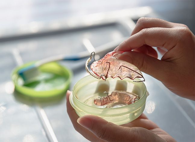 Person placing a retainer in its storage case