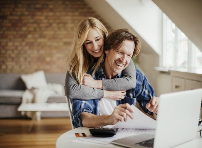 Man and woman reading orthodontist reviews in Oklahoma City on laptop