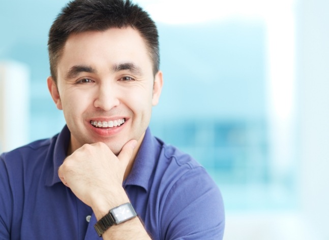 Man in blue polo shirt smiling with braces in Oklahoma City