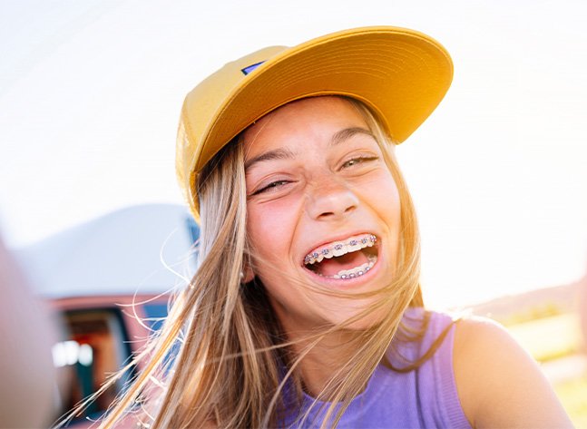 Teenage girl grinning outdoors with traditional braces in Oklahoma City