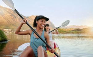 friends kayaking together and smiling