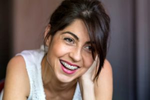 Woman in white tank top with braces