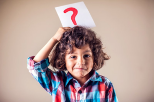 Child holding a card with a question mark over their head